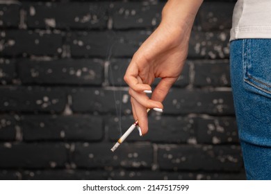Female Hand Holding Lighted Cigarette Close Up