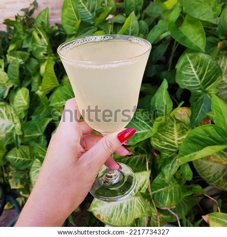 Female hand holding a lime lowcarb drink alcoholic- free. Relaxation and chill out time for a healthy life.