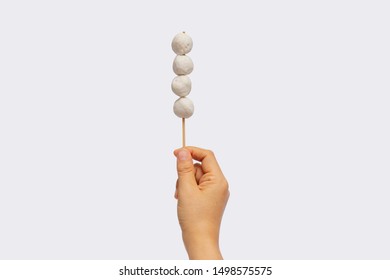 Female hand holding meat ball stick isolated on white background