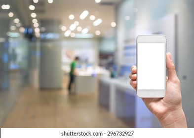 Female Hand Holding Mobile Smart Phone On Store Blur With Bokeh Background, Business Concept