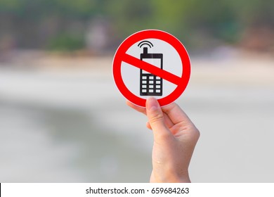 Female hand holding "No phone calls" sign on the beach - Shutterstock ID 659684263