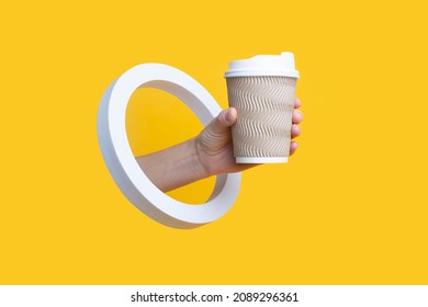 Female Hand Holding Paper Cup In Round Hole On Yellow Background 