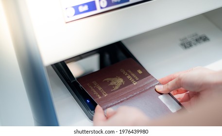 Female Hand Holding Personal Passport Scanning At The Self Service Checkin Counter For Get Boarding Pass At The Airport Terminal.