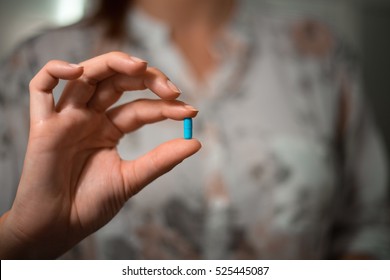 female hand holding pill