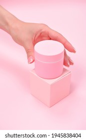 Female Hand Holding Plastic Unbranded Tube On Pink Background. Flacon For Cream, Body Lotion. Container For Cosmetics Product. Skincare And Beauty Concept. Mockup, Copy Space.conceptual Shooting.