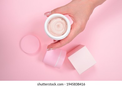 Female Hand Holding Plastic Unbranded Tube On Pink Background. Flacon For Cream, Body Lotion. Container For Cosmetics Product. Skincare And Beauty Concept. Mockup, Copy Space.conceptual Shooting.