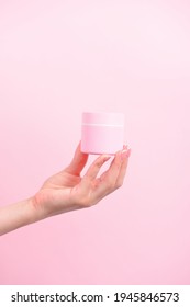 Female Hand Holding Plastic Unbranded Tube On Pink Background. Flacon For Cream, Body Lotion. Container For Cosmetics Product. Skincare And Beauty Concept. Mockup, Copy Space.conceptual Shooting.