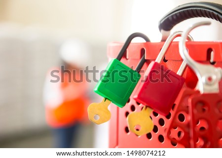 Female hand holding red safe lockout and tagout box