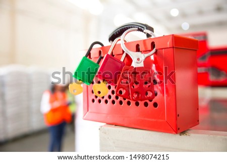 Female hand holding red safe lockout and tagout box