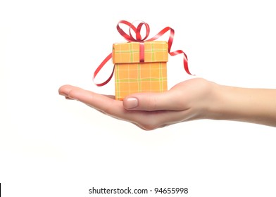 Female Hand Holding Red And Yellow Gift Box With A Bow Isolated On White Background