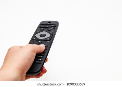Female hand holding a remote for a TV set on a white background - Shutterstock ID 1090383689