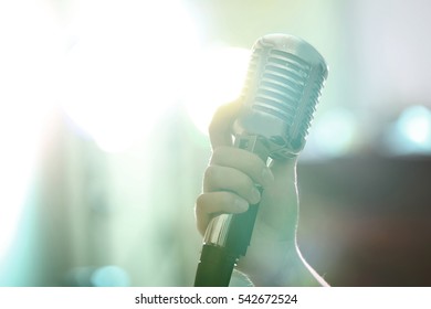 Female hand holding retro microphone, close up - Powered by Shutterstock