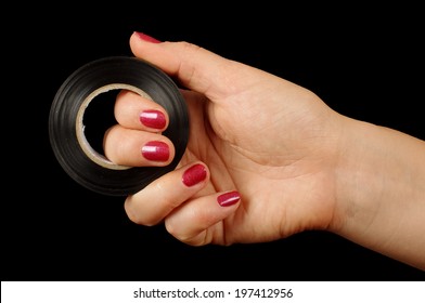 Female Hand Holding Roll Of Duct Tape Isolated On The Black Background