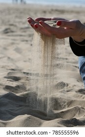 Female Hand Holding Sand Which Is Slipping Through Her Fingers