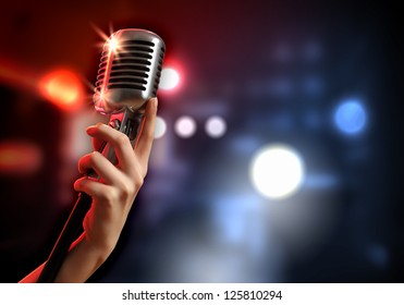 Female hand holding single retro microphone against colourful background