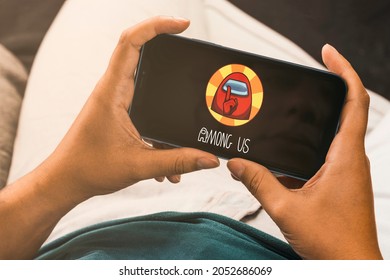 Female hand holding a smartphone with Among us mobile game app on the screen. Rio de Janeiro, RJ, Brazil. September 2021.