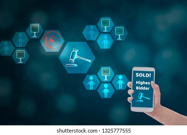 Female Hand Holding Smartphone To Enter The Price For Bid,via Wireless Network On Blue Bokeh Background With Auction Icon, Concept Online Auction Via Website ,application And Modern Technology