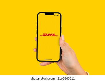 Female Hand Holding A Smartphone IPhone 13 Pro With DHL International Package Delivery And Express Mail Service App On The Screen. Yellow Background. Rio De Janeiro, RJ, Brazil. January 2022.