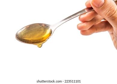 Female Hand Holding A Spoon Of Honey Over White Background