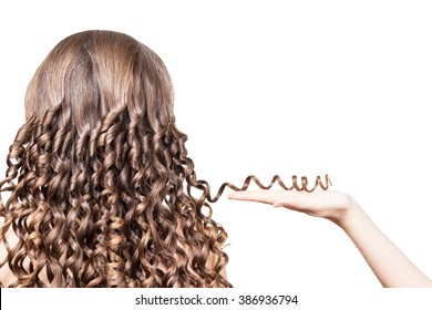 Female hand holding a strand of brown hair curled isolated on a white background. - Shutterstock ID 386936794