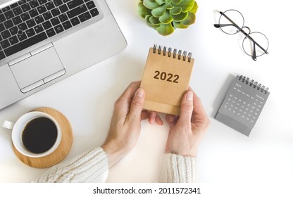 Female Hand Holding Table Calendar. To-do List And Plans For 2022 Goals For Next Year