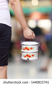 Female Hand Holding Tiffin Or Food Container On Background.