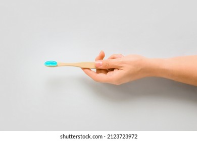 Female Hand Holding Tooth Brush And Paste On White Background