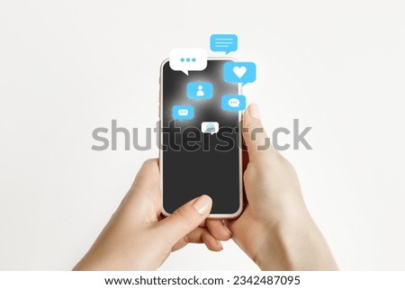 female hand holding and using a social media on mobile phone with notification icons of like, message, comment and star above smartphone screen