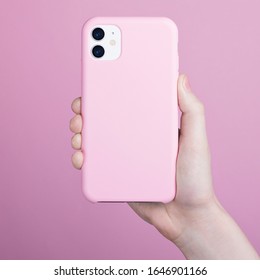 Female Hand Holding White IPhone 11 In Soft Silicone Pink Cover Back View. Phone Case Mock Up