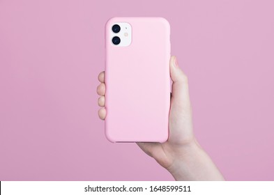 Female Hand Holding White IPhone 11 In Soft Silicone Pink Cover Back View. Phone Case Mock Up