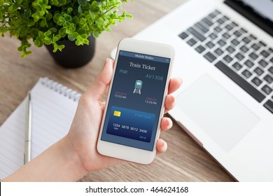 Female Hand Holding White Phone With Online Train Ticket And Notebook