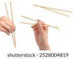 Female hand holding wooden sushi chopsticks isolated on a white background. 