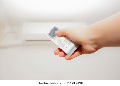 Female Hand Holds Airconditioning Remote Control