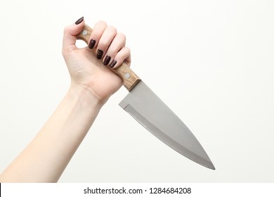 Female hand holds knife on white background.