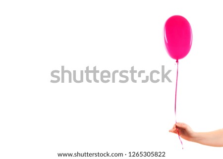 Female hand holds pink rubber inflatable heart shape balloon. Love, relationship, valentines day and birthday celebration concept. Studio shot on an abstract blurred background with blank copy space
