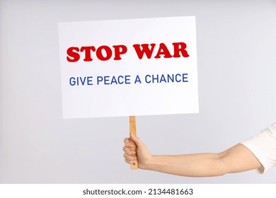 Female Hand Holds Protest Sign With Text: Stop War, Give Peace A Chance