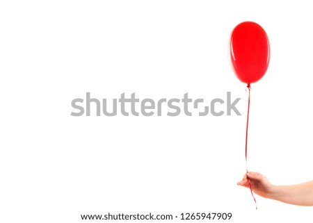 Female hand holds red rubber inflatable heart shape balloon. Love, relationship, valentines day and birthday celebration concept. Studio shot on an abstract blurred background with blank copy space