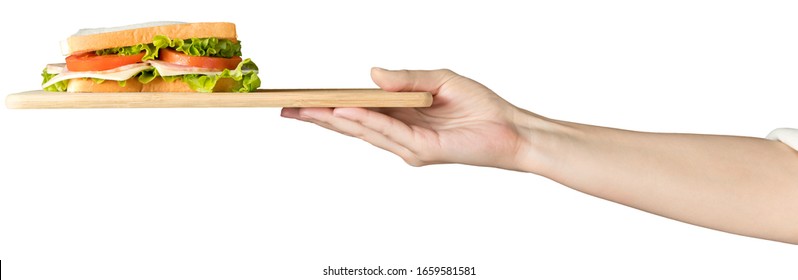 Female hand holds a sandwich with fresh herbs on a wooden tray. Isolated