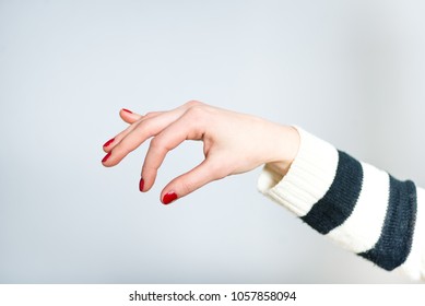 a female hand holds something with her fingers - Powered by Shutterstock