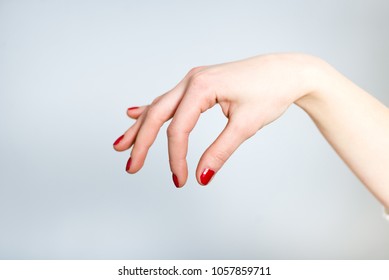 A Female Hand Holds Something With Her Fingers