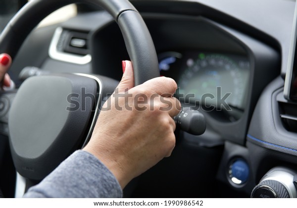 A\
female hand holds the steering wheel of a passenger\
car