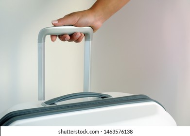 The female hand holds a suitcase for the handle. People with suitcases. Bags for a trip. Concept moving, travel, trip, flight.
 - Shutterstock ID 1463576138