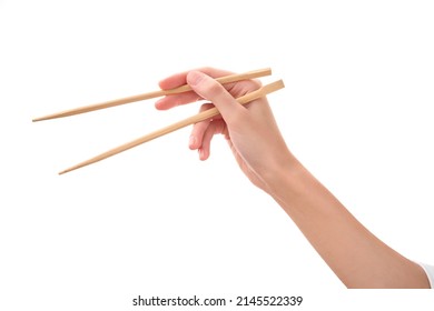 female hand holds Wooden chopsticks isolated on white background. - Shutterstock ID 2145522339