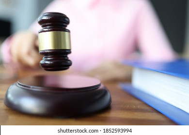 Female hand holds a wooden gavel for judges. Civil Litigation concept