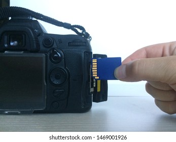 A Female Hand Inserts And Removes A Flash Card Drive From The Camera DSLR.