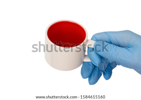 Female hand in latex glove holding an empty cup on a white isolated background