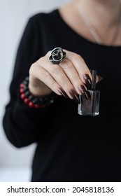 Female hand and long nails   black manicure holds bottle nail polish
