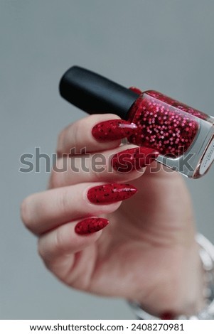 Female hand with long nails and a bright red manicure 