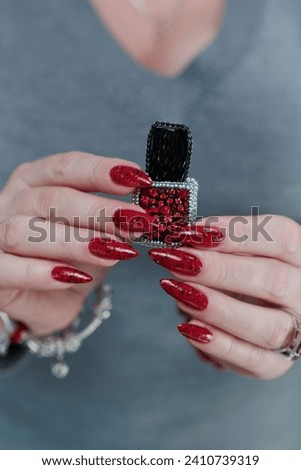 Female hand with long nails and a bright red manicure 
