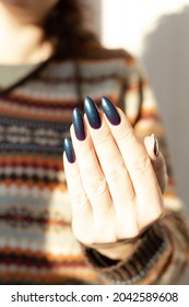 Female hand and long nails   purple   green manicure and bottles nail polish	